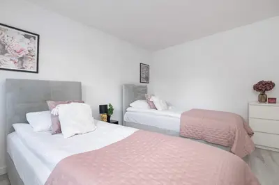a bedroom with two beds with pink and white sheets at Spacious Apartment in Wieliczka with AC & Parking in Wieliczka