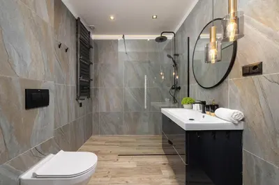 a bathroom with a toilet and a sink and a mirror at Spacious Apartment in Wieliczka with AC & Parking in Wieliczka