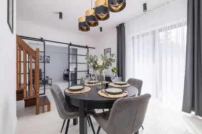 a dining room with a black table and chairs at Spacious Apartment in Wieliczka with AC & Parking in Wieliczka