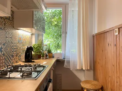 a kitchen with a stove top and a window at Cozy Apartment 10 minutes to Wawel Castle in Kraków
