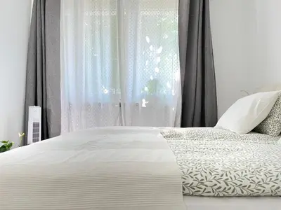 a bedroom with a white bed and a window at Cozy Apartment 10 minutes to Wawel Castle in Kraków