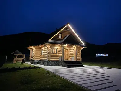 a log cabin with lights on it at night at Chata pod Groniem in Skawica