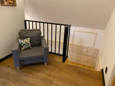 a stair case with a chair and a stair railing at Chata pod Groniem in Skawica