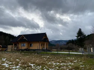 a wooden house in the middle of a field at Chata pod Groniem in Skawica
