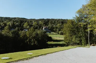 a gravel road with a house in the distance and trees at Hajdukówka Domki in Stróża