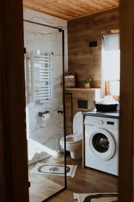 a bathroom with a toilet and a washing machine at Hajdukówka Domki in Stróża
