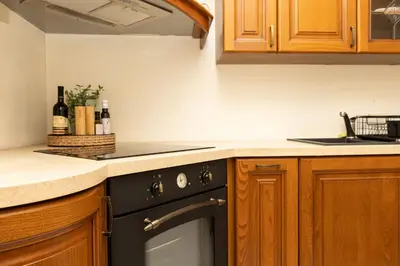 a kitchen with a black oven and wooden cabinets at Apartament Kraków - Cracow Apartment 70m2 in Kraków