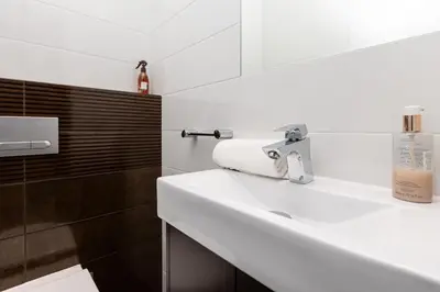 a white bathroom with a sink and a mirror at Apartament Kraków - Cracow Apartment 70m2 in Kraków