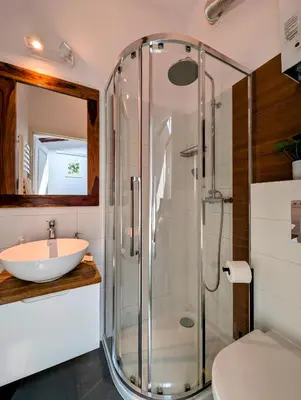 a bathroom with a glass shower and a sink at Dwernickiego 7 by Homeprime in Kraków