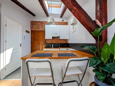a kitchen with a large island with two stools at Dwernickiego 7 by Homeprime in Kraków