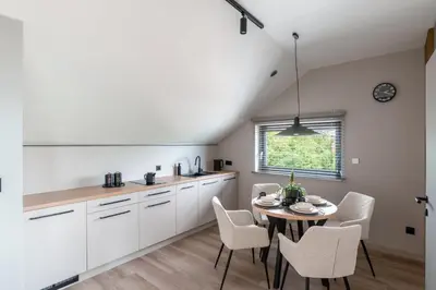 a kitchen and dining room with a table and chairs at Balice Apartamenty Premium - by Upstairs in Cholerzyn