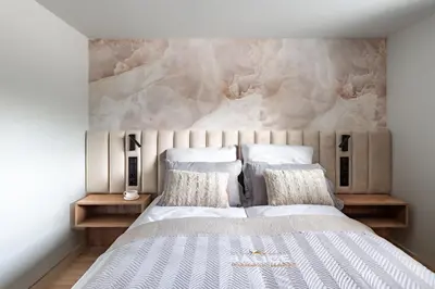 a bedroom with a large bed with a stone wall at Balice Apartamenty Premium - by Upstairs in Cholerzyn
