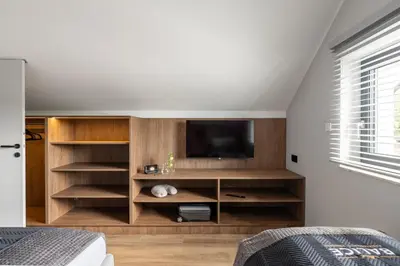 a living room with a tv and wooden shelves at Balice Apartamenty Premium - by Upstairs in Cholerzyn