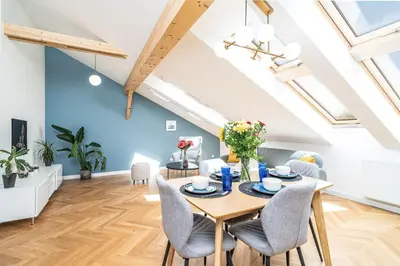 a living room with a wooden table and chairs at ShortStayPoland Siemieńskiego C5 in Kraków