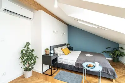 a bedroom with a bed and a blue wall at ShortStayPoland Siemieńskiego C5 in Kraków