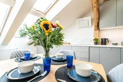 a dining room table with a vase of flowers on it at ShortStayPoland Siemieńskiego C5 in Kraków