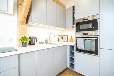 a kitchen with white cabinets and a stove top oven at ShortStayPoland Siemieńskiego C5 in Kraków