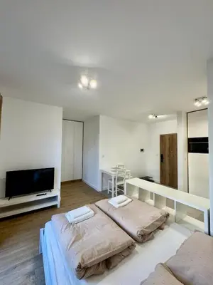 a bedroom with two beds and a flat screen tv at Apartamenty RS Kazimierza Wielka in Kazimierza Wielka