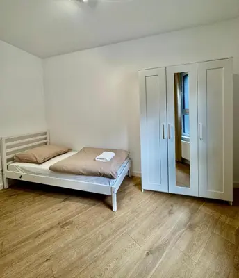 a bedroom with a bed and a cabinet in it at Apartamenty RS Kazimierza Wielka in Kazimierza Wielka