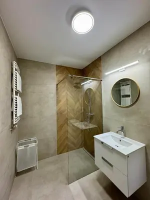 a bathroom with a shower and a sink and a mirror at Apartamenty RS Kazimierza Wielka in Kazimierza Wielka