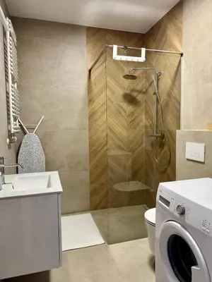 a bathroom with a shower and a washing machine at Apartamenty RS Kazimierza Wielka in Kazimierza Wielka