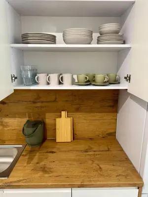 a kitchen shelf with plates and bowls on it at Apartamenty RS Kazimierza Wielka in Kazimierza Wielka