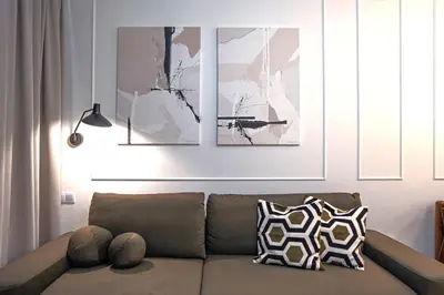 a living room with a brown couch and two paintings at Apartment next to Wawel, Premium Stay in Central Krakow by Koletek 3 in Kraków