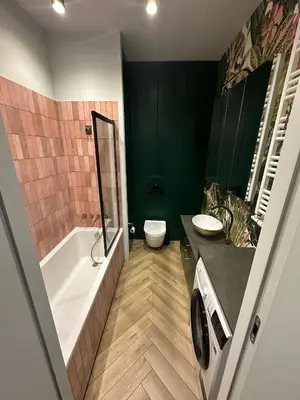 a bathroom with a tub and a toilet and a sink at Pink Apartment Zabłocie in Kraków
