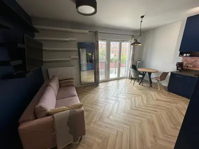 a living room with a couch and a table at Pink Apartment Zabłocie in Kraków