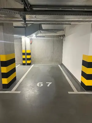 a parking garage with a parking sign on the floor at Pink Apartment Zabłocie in Kraków