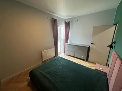 a bedroom with a bed and a dresser and a mirror at Pink Apartment Zabłocie in Kraków