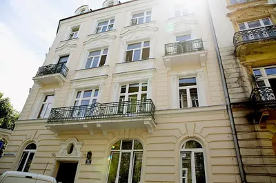 a building with a balcony and trees in front of it at Elegant Studio Bonerowska in Kraków