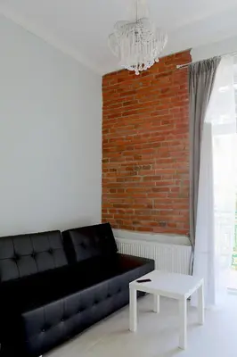 a kitchen with a loft bed and a spiral staircase at Elegant Studio Bonerowska in Kraków