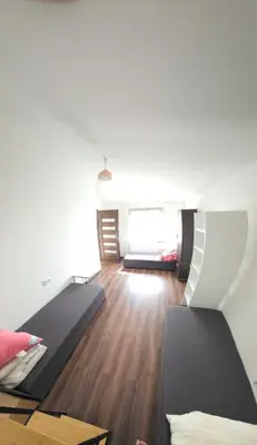 a room with two beds and a wooden floor at Fabryka Snów NC in Niepołomice