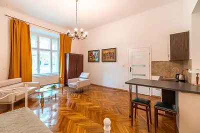 a living room with a table and a kitchen at Straszewskiego view in Kraków