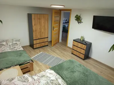 a room with two beds and a flat screen tv at Apartament Gorczański Widok in Nowy Targ
