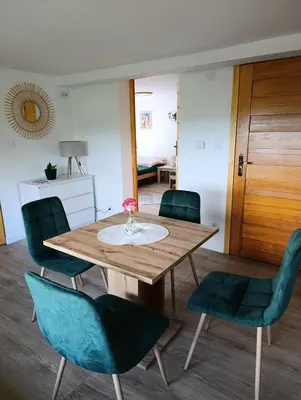 a dining room with a wooden table and chairs at Apartament Gorczański Widok in Nowy Targ