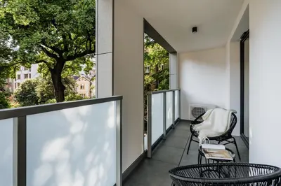 a balcony with two chairs and a tree at Electra Apartments by StayLab in Kraków