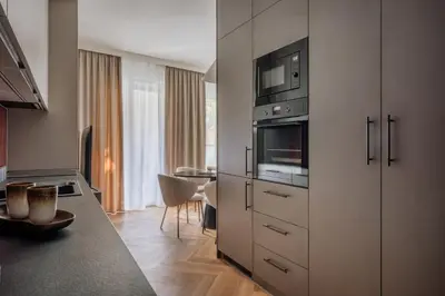 a kitchen with white cabinets and a counter top at Electra Apartments by StayLab in Kraków