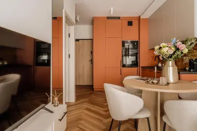 a kitchen with a table with chairs and a vase of flowers at Electra Apartments by StayLab in Kraków