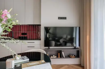 a living room with a tv and a table with a chair at Electra Apartments by StayLab in Kraków