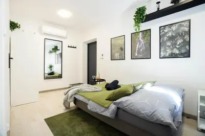 a bedroom with a bed in a white room at Wiślane Apartamenty Kraków in Kraków