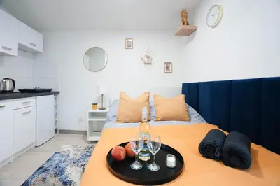 a room with a bed with a tray with wine glasses at Wiślane Apartamenty Kraków in Kraków