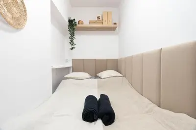 a bed with two pairs of black socks on it at Wiślane Apartamenty Kraków in Kraków