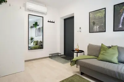 a living room with a couch and some pictures on the wall at Wiślane Apartamenty Kraków in Kraków