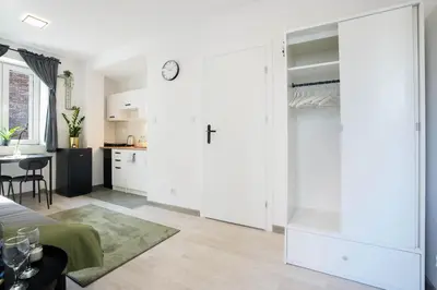 a kitchen and a living room with a large white closet at Wiślane Apartamenty Kraków in Kraków