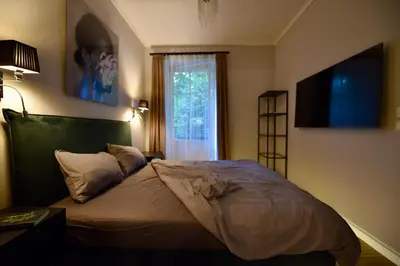 a bedroom with a large bed with a window at AWapartaments in Kraków