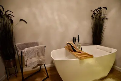 a white bath tub in a bathroom with plants at AWapartaments in Kraków