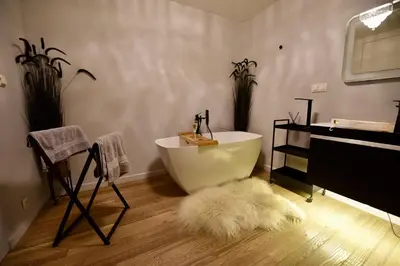 a bathroom with a white bath tub and a rug at AWapartaments in Kraków