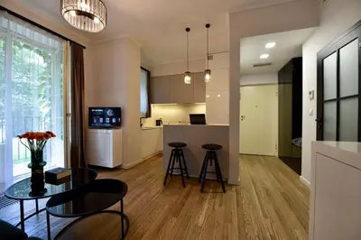 a kitchen and living room with a table and chairs at AWapartaments in Kraków